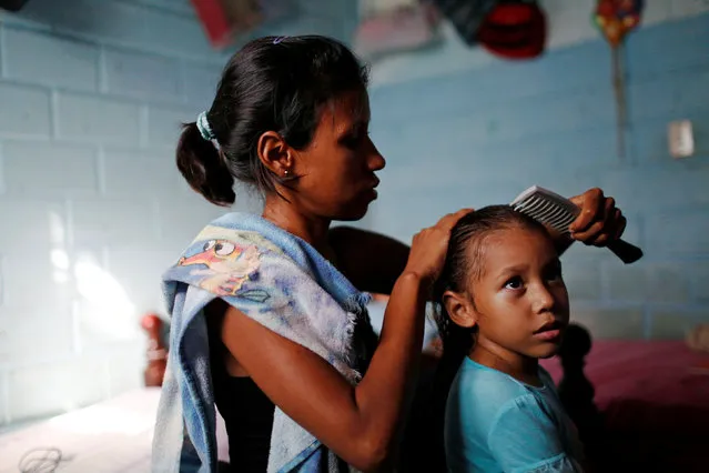 Alejandra Jordan, 30, combs her daughter Valeria's hair at their home in San Francisco de Yare, Venezuela July 11, 2016. (Photo by Carlos Garcia Rawlins/Reuters)