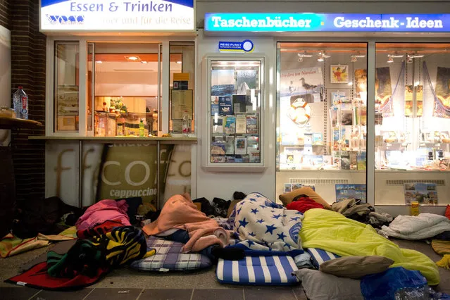 Refugees sleep at the train station in Flensburg, Germany, 10 September 2015. A first train with refugees left in the morning from Flensburg towards Denmark. About 100 migrants spent the night at Flensburg's train station. Denmark would resume international rail services to Germany on 10 September, the Danish railway company DSB said, the day after trains were halted in an attempt to come to terms with an influx of migrants. (Photo by Christian Charisius/EPA)