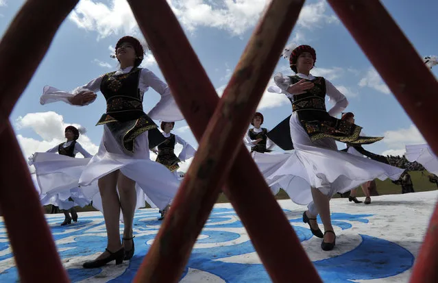 Kyrgyz women wearing traditional costumes perform during a traditional folk festival at Son-Kul lake, 3016 metres above the sea level, some 350 kms from Bishkek on July 29, 2016. The festival marks the 220th anniversary of the national hero Tailak Baatyr. (Photo by Vyacheslav Oseledko/AFP Photo)