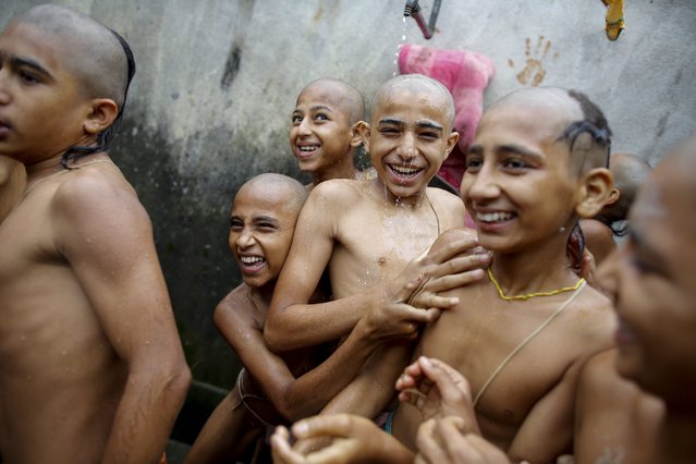 Nepalese students of a Hindu school bathe during Janai Purnima Festival celebrations at the Pashupati temple in Kathmandu, Nepal, 18 August 2016. During Janai Purnima, also known as the Sacred Thread festival or Rakshya Bandhan festival, Hindu men, especially the Brahmans and Chettris, perform their annual change of Janai, sacred threads worn across the chest or tied around the wrist. Purified by mantras, the thread is a symbol of protection, according to Hindu belief. The festival also marks the end of the monsoon season. (Photo by Narendra Shrestha/EPA)