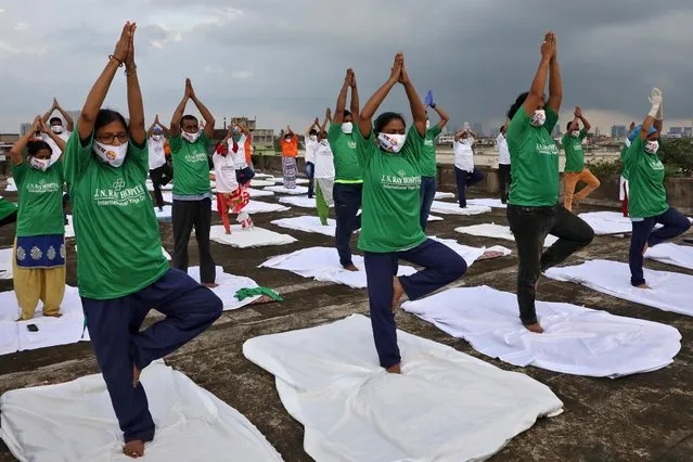 Staff members of a hospital wearing protective face masks perform yoga on the rooftop of their hospital building during International Yoga Day, in Kolkata, India, June 21, 2020. (Photo by Rupak De Chowdhuri/Reuters)
