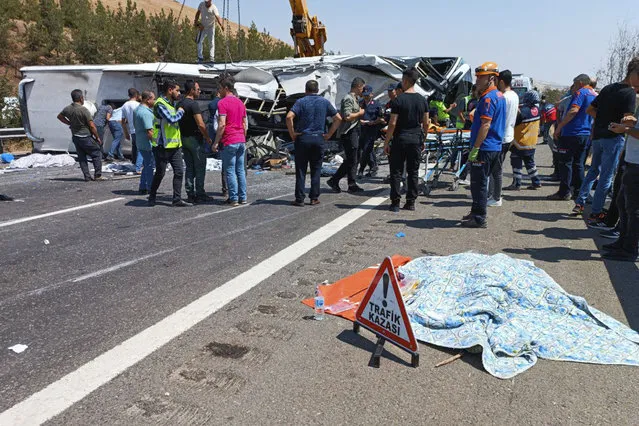 Emergency and rescue teams attend the scene after a bus crash accident on the highway between Gaziantep and Nizip, Turkey, Saturday, August 20, 2022. Officials in southern Turkey say at least 15 people were killed when a passenger bus collided with emergency teams handling an earlier road accident. (Photo by IHA via AP Photo)