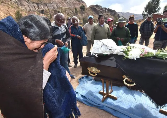 Relatives and miner friends mourn the body of Fermin Mamani, one of the protester miners who died allegedly after clashes with the police, in a central route between La Paz and Cochabamba, during a three day block by workers whom oppose a union bill promoted by Bolivian President, Evo Morales, Sayari, Cochabamba department, on 25 August 2016. The conflict escalated after this Wednesday the main union of the protest Fencoming, denounced that two miners died from gun wounds during clashes with the Bolivian police. The Bolivian Government said in an official statement that only one died. (Photo by Jorge Abrego/EFE)