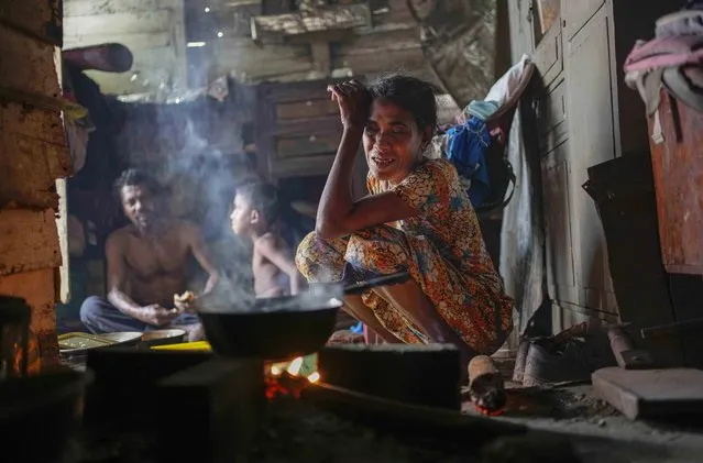 A woman sits by the fireplace at meal time in a shanty in Colombo, Sri Lanka, Wednesday, October 5, 2022. International creditors should provide debt relief to Sri Lanka to alleviate suffering as its people endure hunger, worsening poverty and shortages of basic supplies, Amnesty International said in a statement Wednesday. (Photo by Eranga Jayawardena/AP Photo)