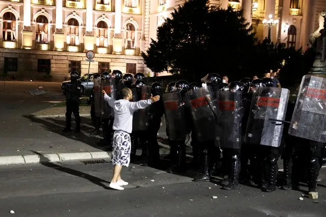 A demonstrator gestures in front of security forces during a protest in Belgrade, Serbia July 7, 2020. Serbia, a country of 7 million people, has reported 16,168 coronavirus infections and 330 deaths. But the numbers are spiking and 299 cases and 13 deaths were reported just on Tuesday. (Photo by Marko Djurica/Reuters)