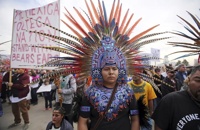 A supporter of the Bears Ears and Grand Staircase-Escalante National Monuments wears a colorful headdress during a rally Saturday, December 2, 2017, in Salt Lake City. President Donald Trump is expected to announce plans next week to shrink the two sprawling Utah national monuments by reversing actions taken by former President Barack Obama. (Photo by Rick Bowmer/AP Photo)