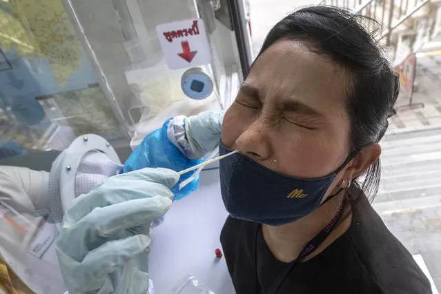 A health worker collects a nasal swab from a woman for a coronavirus test in Rayong province, Thailand, Tuesday, July 14, 2020. Authorities set up testing for anyone concerned they might have come into contact with an Egyptian soldier who visited a shopping mall in Rayong last week and then tested positive for COVID-19. In Thailand, where there has been no reports of locally transmitted cases for seven weeks, health authorities were rushing to trace the contacts of two recent foreign arrivals in the country who were infected with the coronavirus and may have violated quarantine rules. (Photo by Sakchai Lalit/AP Photo)