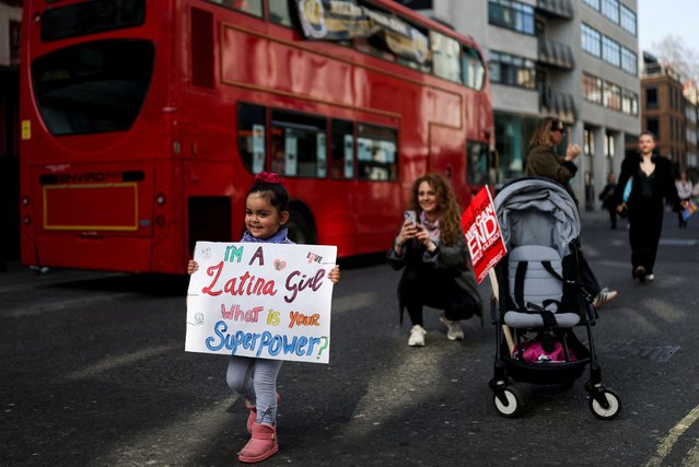 Lourdes, 3, holds a placard next to a bus, on the day of the Million Women Rise march, during the International Women's Day in London, Britain, on March 8, 2025. (Photo by Hannah McKay/Reuters)