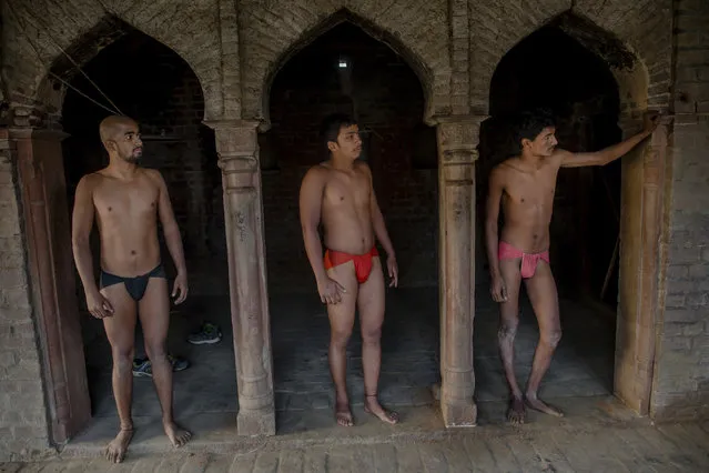 In this November 22, 2017 photo, Indian Kushti wrestlers wait for their turn to practice push ups, during their daily training, at an akhada, a kind of wrestling hostel at Bahadurgarh, in Haryana, India. (Photo by Dar Yasin/AP Photo)