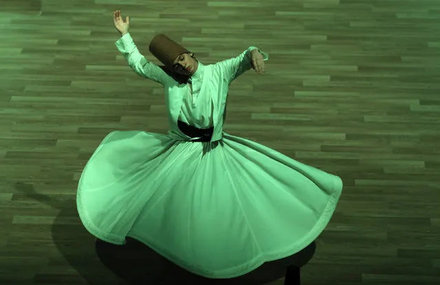 A whirling dervish performs a “Sema” ritual during a ceremony, one of many marking the 744th anniversary of the death of Mevlana Jalaluddin Rumi, the father of Sufism who lived in the 13th century, at Mevlana Cultural Center in Konya, on December 19, 2017. (Photo by Adem Altan/AFP Photo)