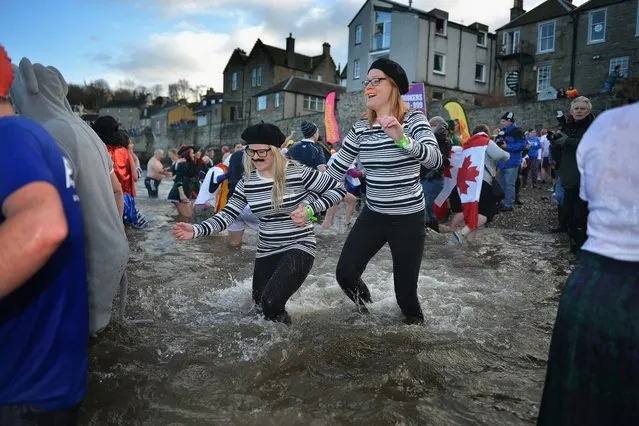 Over 1,000 New Year swimmers, many in costume, brave the freezing conditions in the River Forth in front of the Forth Rail Bridge during the annual Loony Dook Swim on January 1, 2013 in South Queensferry, Scotland. Thousands of people gathered last night to see in the New Year at Hogmanay celebrations in towns and cities across Scotland.  (Photo by Jeff J. Mitchell)