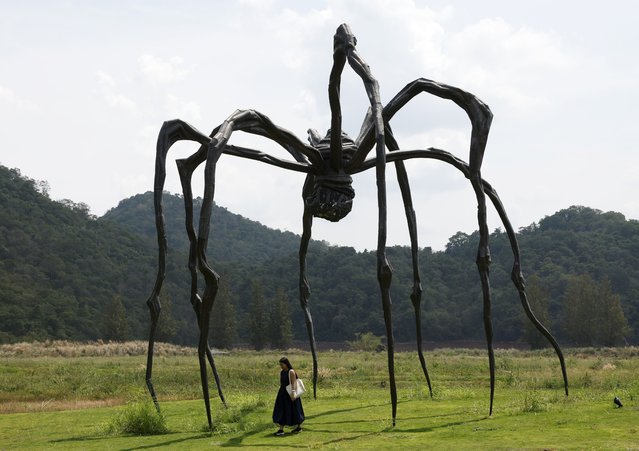 A visitor views the sculpture “Maman”, created by Louise Bourgeois and displayed in a woodland at Khao Yai Art Forest, near Khao Yai national park in Pak Chong district, Nakhon Ratchasima province, Thailand, 06 April 2025. The newly opened art sanctuary, Khao Yai Art Forest, is part of a reforestation project transforming a forest near Thailand's oldest Khao Yai national park to an innovative open air art museum where creativity and nature are blended. Khao Yai Art Forest allows visitors to wander through woodlands beneath towering trees to experience art installations blending with nature under the “healing through art” concept aimed to raise awareness to protect nature which in turn nurtures the human body and mind, as well as to promote the place as a new destination for art enthusiasts worldwide. (Photo by Rungroj Yongrit/EPA)