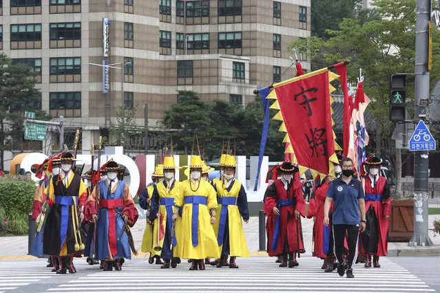 South Korean Imperial guards wearing face masks to help protect against the spread of the coronavirus cross a road in Seoul, South Korea, Wednesday, August 5, 2020. (Photo by Ahn Young-joon/AP Photo)