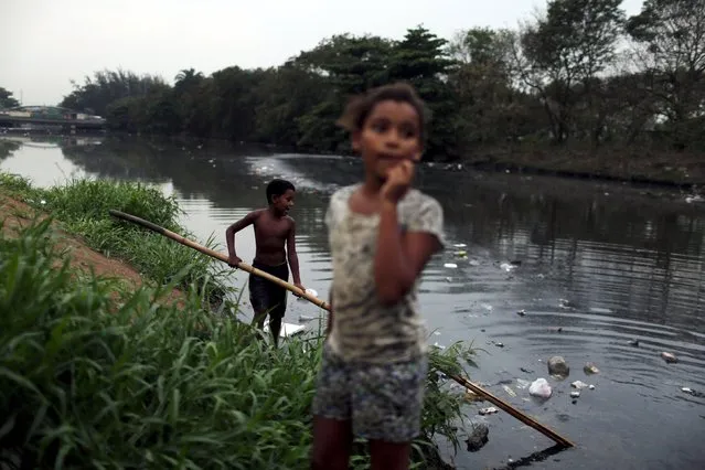 Children play next to a polluted canal at a slum in Rio de Janeiro, Brazil, September 30, 2015. (Photo by Pilar Olivares/Reuters)