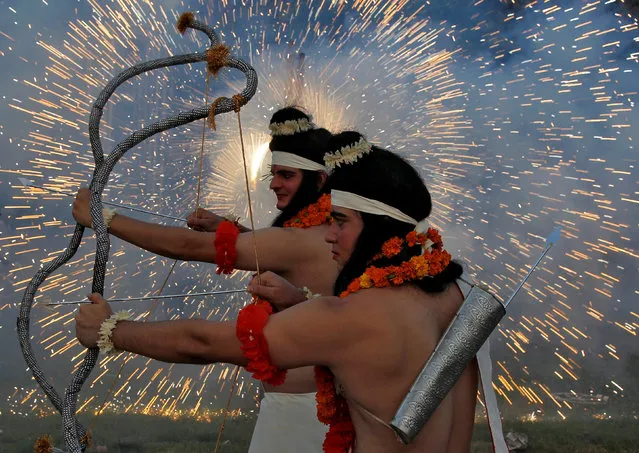 Artists dressed as Hindu gods Rama and Laxman act as fireworks explode during Vijaya Dashmi, or Dussehra festival celebrations in Chandigarh, India, September 30, 2017. (Photo by Ajay Verma/Reuters)