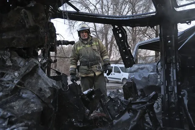 A firefighter examines a burned car after what Russian officials in Donetsk said was a shelling by Ukrainian forces, in Donetsk, the capital of Russian-controlled Donetsk region, eastern Ukraine, Thursday, December 15, 2022. (Photo by Alexei Alexandrov/AP Photo)