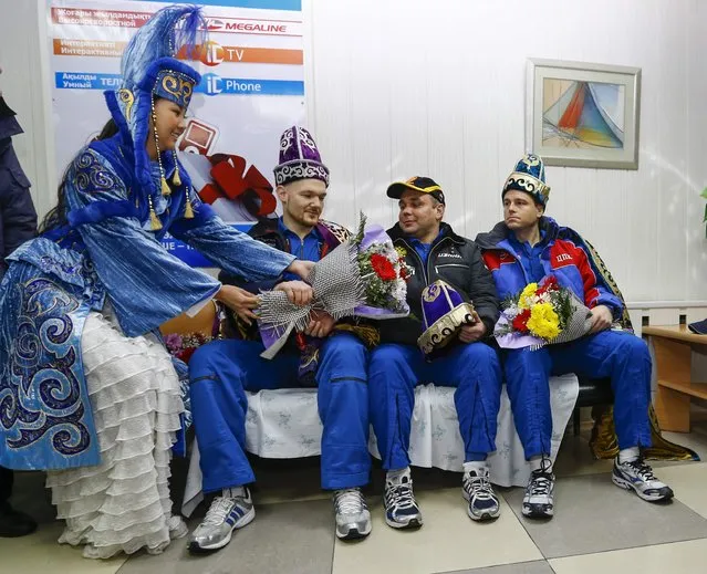 International Space Station (ISS) crew members Alexander Gerst of Germany (L), Maxim Suraev of Russia (C) and Reid Wiseman of the U.S. are welcomed on arrival to Kostanay after landing in northern Kazakhstan November 10, 2014. (Photo by Shamil Zhumatov/Reuters)