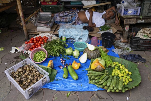 A roadside vegetable vendor takes a midday nap in Kolkata, India, Friday, November 22, 2024. (Photo by Bikas Das/AP Photo)
