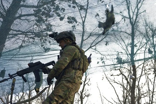 A cat walks atop a net as a Ukrainian soldier takes position during fights with Russian forces near Maryinka, Donetsk region, Ukraine, Friday, December 23, 2022. (Photo by Libkos/AP Photo)