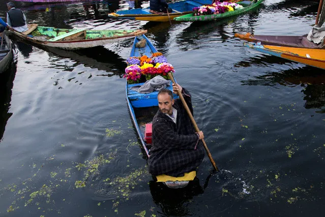 A Kashmiri flower vendor rows his boat at the floating vegetable market on Dal lake in Srinagar, Indian controlled Kashmir, Tuesday, October 6, 2015. Vegetables traded in this floating market are supplied to Srinagar and many towns across the Kashmir valley. It's one of the major sources of income for the lake dwellers who spend years carefully nurturing their floating gardens from the weed and rich soil extracted from the lake bed. Sometimes a boat will weave through, selling flowers to the tourists who stay in the houseboats. (Photo by Dar Yasin/AP Photo)