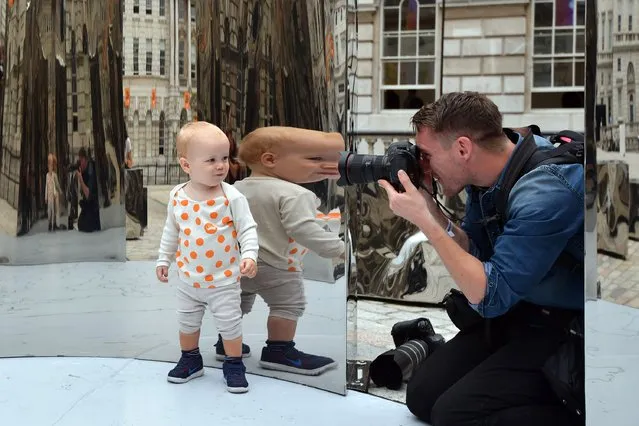 17 -month-old Hugo Malcomson is reflected as he is photographed exploring an installation entitled “Bliss” created by Helidon Xhixha who is representing Albania at the London Design Biennale at Somerset House on September 6, 2016 in London, England. (Photo by Carl Court/Getty Images)