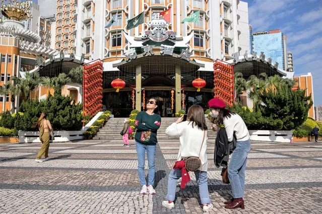 Mainland Chinese tourists take photos outside the Lisboa Casino in Macau, China, 22 January 2023. Macau borders reopened earlier this month and the city has launched a promotional campaign to boost tourism, offering Hong Kong residents a 'half-price' round-trip if travellers spend a night there during the Chinese Lunar New Year period. The  Chinese lunar new year, also called “Spring Festival”, falls on 22 January 2023, marking the beginning of the Year of the Rabbit. (Photo by Jerome Favre/EPA/EFE)