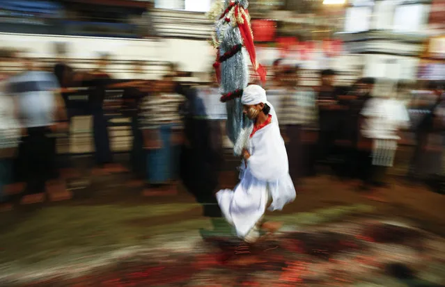 A Myanmar Shiite Muslim devotee runs  barefoot over a bed of burning coals as he takes part in a Muharram procession ahead of the Islamic holiday Ashura, in Yangon, Myanmar, October 22, 2015. Muslims across the world are observing Moharram, the first month of Islamic calender, the climax of Moharram is the Ashura festival commemorating the martyrdom of Imam Hussein, a grandson of the Prophet Mohammed in the Iraqi city of Karbala in the seventh century. (Lynn Bo Bo/EPA)