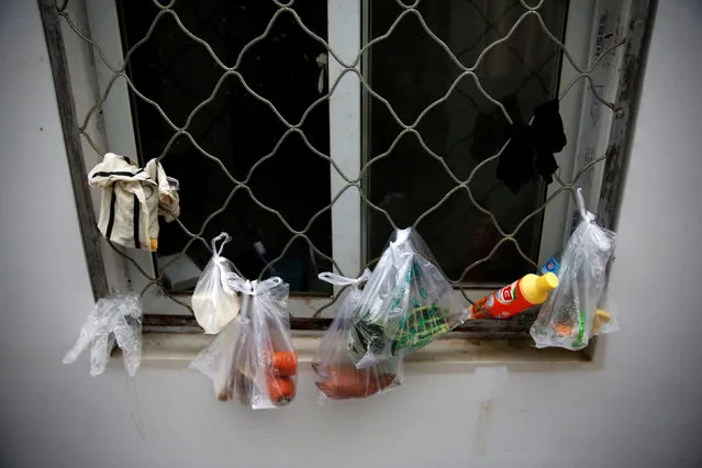 Groceries in plastic bags hang by the window at the accommodation where some patients and family members stay while seeking medical treatment in Beijing, China, October 23, 2015. (Photo by Kim Kyung-Hoon/Reuters)