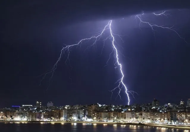 A lightning bolt strikes during a thunderstorm in Montevideo early on August 27, 2022. (Photo by Mariana Suarez/AFP Photo)