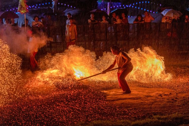 A barefooted villager walks through burning charcoal as he performs in the traditional ritual “Lianhuo”, or “fire walking”, at Huaxi Scenic Area on August 2, 2025 in Pan'an County, Jinhua City, Zhejiang Province of China. (Photo by Hu Xiaofei/VCG via Getty Images)