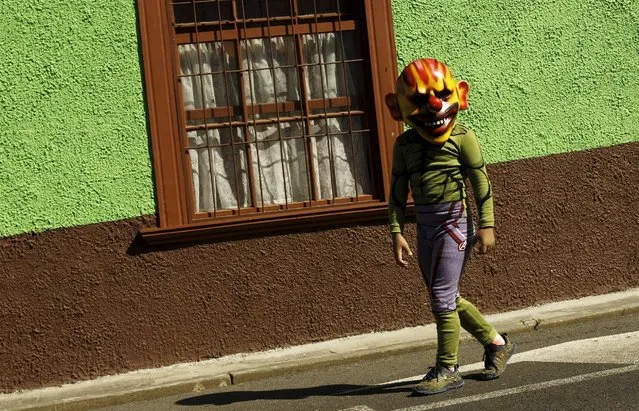 A boys wears a mask as he takes part in a parade during the National Encounter of Mask festival in Barva de Heredia, October 30, 2015. (Photo by Juan Carlos Ulate/Reuters)