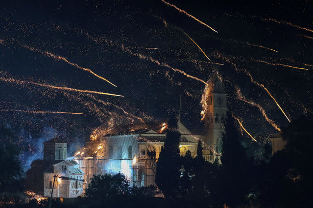 Handmade rockets fly over Panagia Erithiani church during Greek Orthodox Easter celebrations in the village of Vrontados, on the island of Chios, Greece, on May 4, 2024. During the Orthodox Easter midnight mass service residents of two “rival” churches, Panagia Erithiani and Saint Mark, fire handmade firework-like rockets at each other's steeples, unleashing thousands of rockets into the night sky, in a tradition going back generations. (Photo by Konstantinos Anagnostou/Reuters)