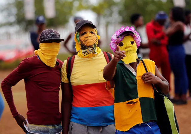 Protesters wearing masks gesture to a photographer after disrupting lectures during protests demanding free tertiary education at the North-West University (NWU Vaal) in Vanderbijlpark, South of Johannesburg, South Africa, October 17, 2016. (Photo by Siphiwe Sibeko/Reuters)