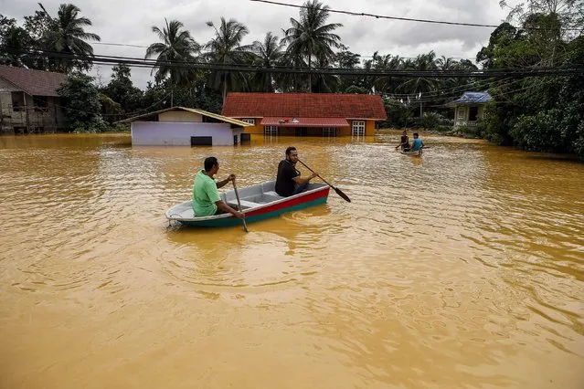 A villagers used a boat to see their home submerged by floodwater at Kota Bharu district of Kelantan, Malaysia, 28 December 2014. The  Malaysian government described this flood as the worst in 30 years, at least five people were killed and more than 118,000 people have sought shelter in the hundreds of evacuation centers opened by the government. (Photo by Azhar Rahim/EPA)