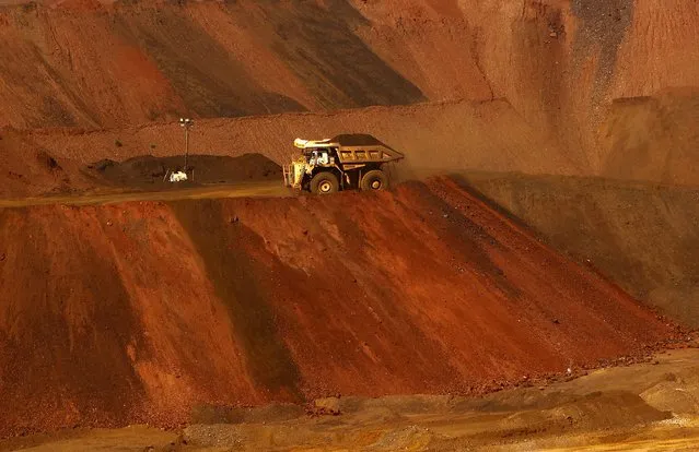 A truck carrying iron ore moves along a road at the Fortescue Metals Group (FMG) Christmas Creek iron ore mine located south of Port Hedland in the Pilbara region of Western Australia, November 17, 2015. (Photo by Jim Regan/Reuters)