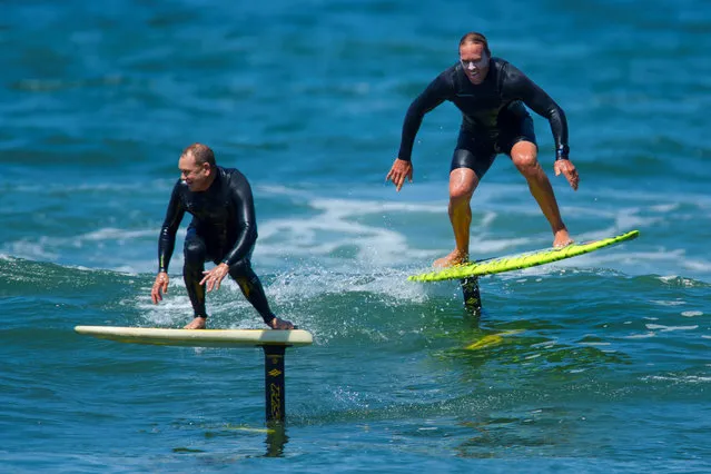 Surfers Chuck Patterson and Gary Clisby ride their foil boards on a morning swell of the coast of Carlsbad, California on May 23, 2018. Increased speed, combined with the foil's sharp metal blade, have led to the sport gaining a reputation as dangerous. (Photo by Mike Blake/Reuters)