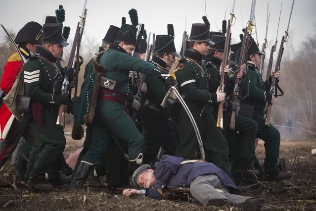 A reenactor playing the roll of a British soldier mocks stabbing a fallen United States fighter during a reenactment of the Battle of New Orleans in the War of 1812, marking its  bicentennial  in Chalmette, Louisiana January 10, 2015. (Photo by Lee Celano/Reuters)