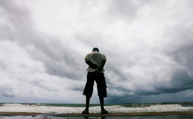 A man looks at the rough sea as rainy clouds gather above during the monsoon period in Colombo, Sri Lanka May 21, 2018. (Photo by Dinuka Liyanawatte/Reuters)