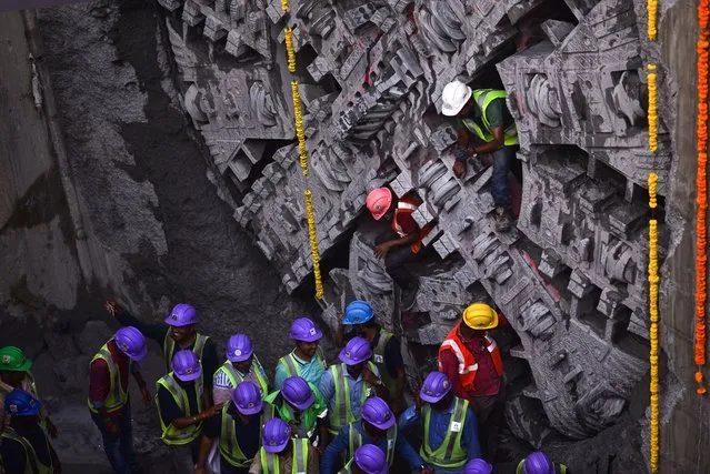 Construction workers come out through the Anaimalai tunnel boring machine (TBM) after it broke the wall to complete the digging process at an under-construction metro station during the Phase-II construction of the Chennai metro rail project, in Chennai, India, 07 June 2023. (Photo by Idrees Mohammed/EPA)