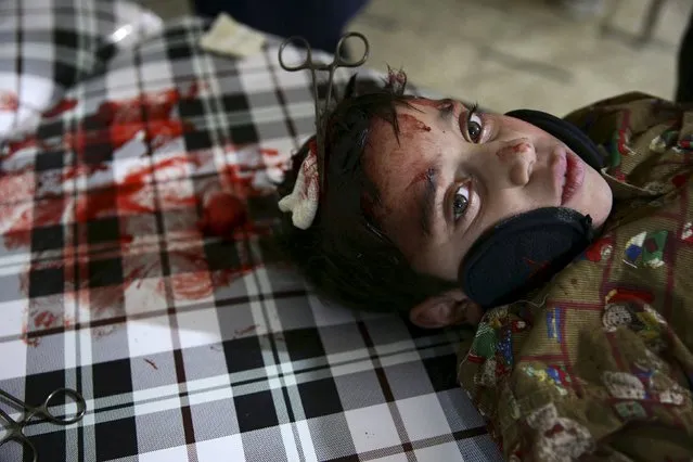 An injured boy who is undergoing surgery, after he was injured in what activists said was an airstrike by forces loyal to Syria's president Bashar al-Assad, rests inside a field hospital in the Douma neighborhood of Damascus, Syria December 5, 2015. (Photo by Bassam Khabieh/Reuters)
