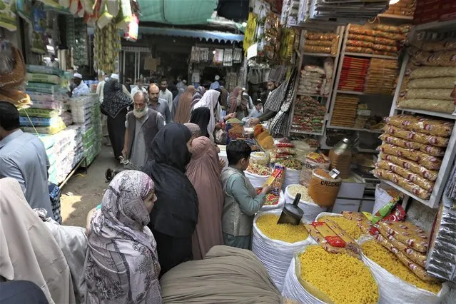 People visit a market to buy grocery and other stuff, ahead of the upcoming Muslim fasting month of Ramadan, in Peshawar, Pakistan, Tuesday, March 21, 2023. Muslims across the world will be observing the Ramadan, when they refrain from eating, drinking and smoking from dawn to dusk. Ramadan is expected to officially begin Thursday or Friday in Pakistan, though the timing depends on the alignment of the moon. (Photo by uhammad Sajjad/AP Photo)