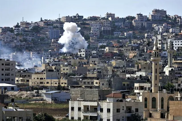 Smoke rises during an Israeli military raid of the militant stronghold of Jenin in the occupied West Bank, Monday, July 3, 2023. Palestinian health officials say at least three Palestinians were killed in the raid. (Photo by Majdi Mohammed/AP Photo)
