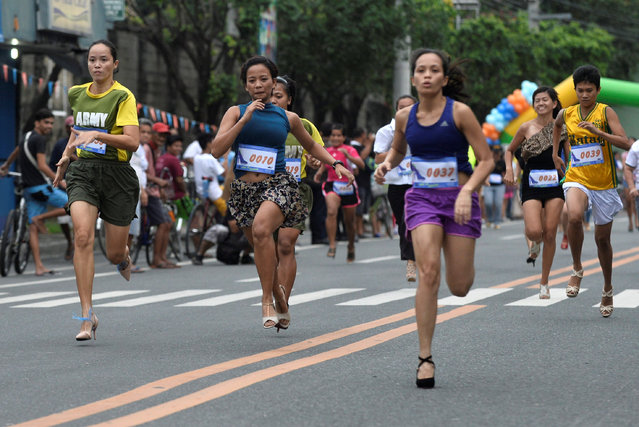 Participants wearing stilettos run as they compete in the “Tour De Takong” stiletto race, as part of activities for the town's annual shoe festival, along Shoe Avenue in Marikina city, Metro Manila, Philippines November 26, 2016. (Photo by Ezra Acayan/Reuters)