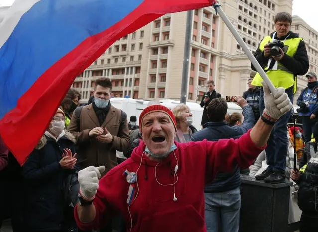A supporter waves Russian flag and shouts slogans during the opposition rally in support of jailed opposition leader Alexei Navalny in Moscow, Russia, Wednesday, April 21, 2021. Police across Russia have arrested more than 180 people in connection with demonstrations in support of imprisoned opposition leader Alexei Navalny, according to a human rights group. (Photo by Alexander Zemlianichenko/AP Photo)