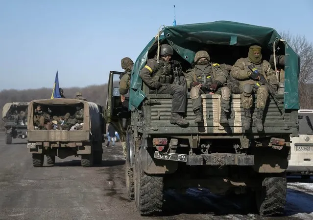 Ukrainian servicemen ride on a military vehicle as they leave area around Debaltseve, eastern Ukraine near Artemivsk February 18, 2015. (Photo by Gleb Garanich/Reuters)