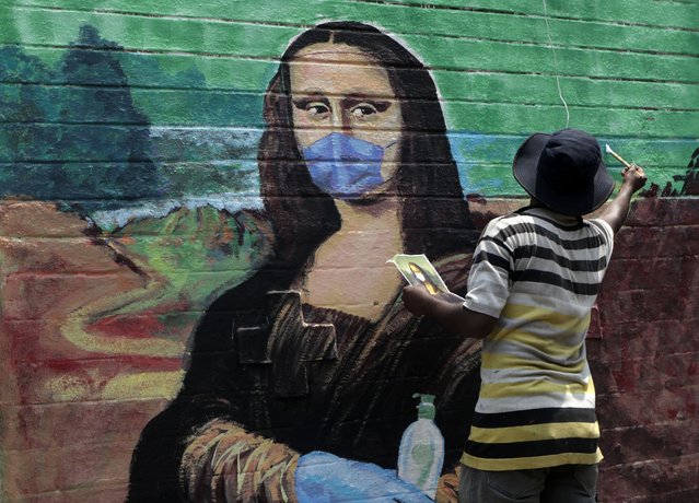 An artist makes a mural of  the Monalisa wearing a face mask to spread awareness for the prevention of the coronavirus in Mumbai, India, Wednesday, March 24, 2021. (Photo by Rajanish Kakade/AP Photo)