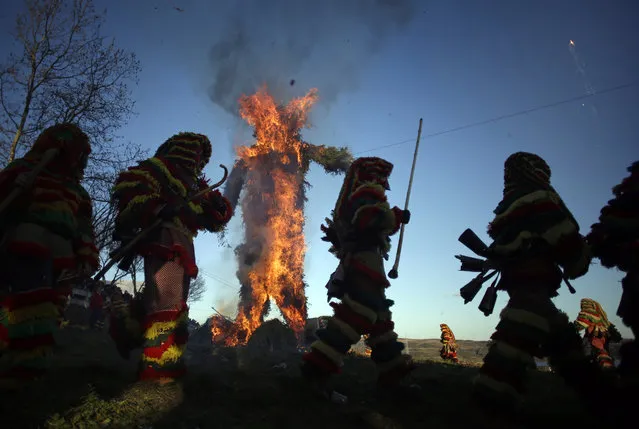 In this photo taken on Tuesday, February 17, 2015 revellers dressed in traditional costumes run around a burning effigy of a traditional figure during annual Carnival festivities, in Podence, northeastern Portugal. (Photo by Francisco Seco/AP Photo)