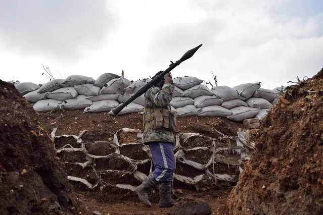 An opposition fighter from the Sham brigade walks holding a rocket-propelled grenade in a trench on the front line during the ongoing clashes with government forces in the village of Teir Maalah in Syria's central Homs province on December 5, 2016. (Photo by Mahmoud Taha/AFP Photo)