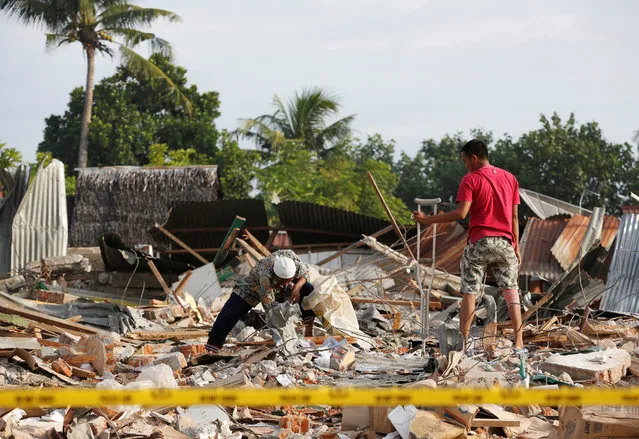 Men look for items to salvage from a building which collapsed following this week's strong earthquake in  Pidie Jaya, Aceh province, Indonesia December 10, 2016. (Photo by Darren Whiteside/Reuters)