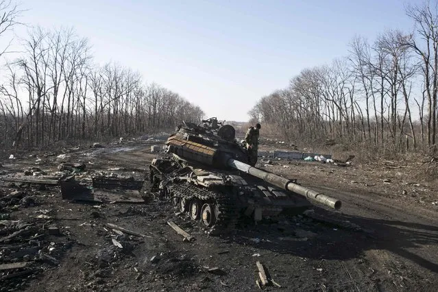 A fighter with the separatist self-proclaimed Donetsk People's Republic army looks at a destroyed Ukrainian army tank near the town of Debaltseve February 22, 2015. Pro-Moscow rebels said they would start to withdraw heavy weapons from the front line in eastern Ukraine on Sunday but the government in Kiev said armoured columns had crossed the border from Russia to reinforce the separatists.   
REUTERS/Baz Ratner(UKRAINE - Tags: POLITICS CIVIL UNREST CONFLICT MILITARY TPX IMAGES OF THE DAY)